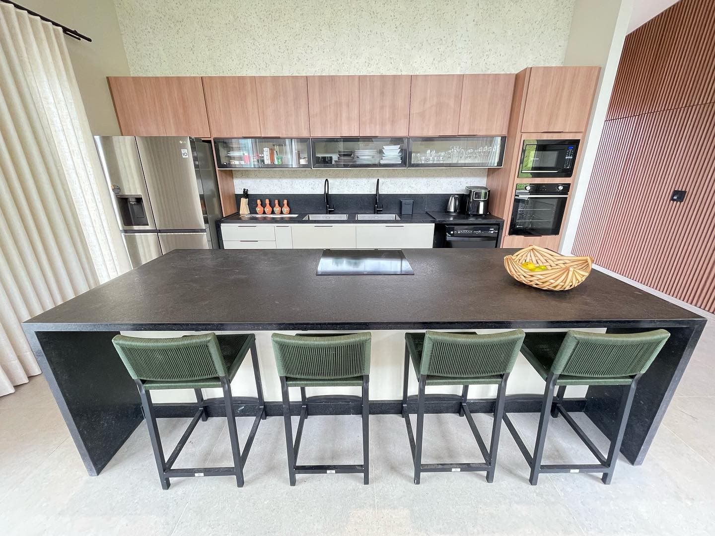 Cozinha planejada com ilha em granito preto e armários amadeirados