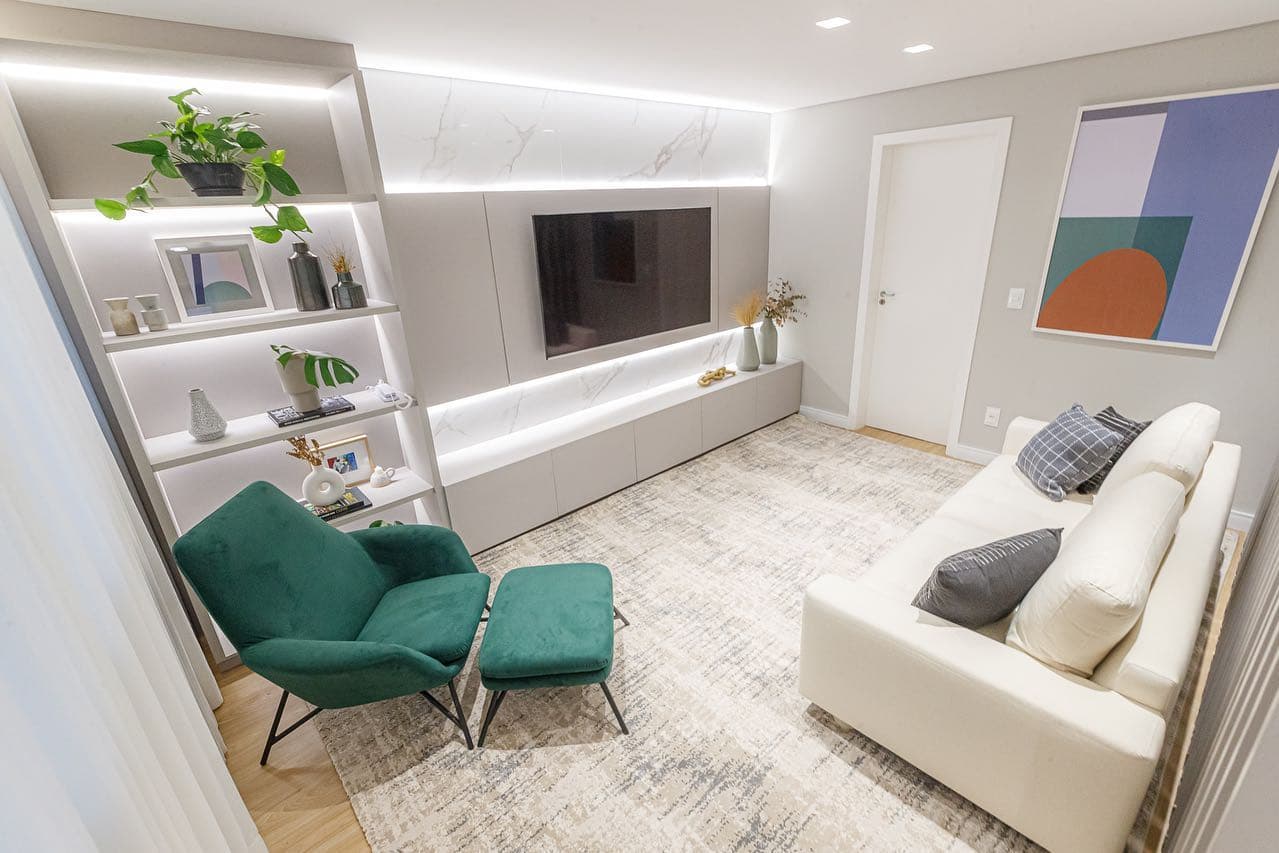 Sala de estar com estante iluminada e painel de TV em porcelanato marmorizado